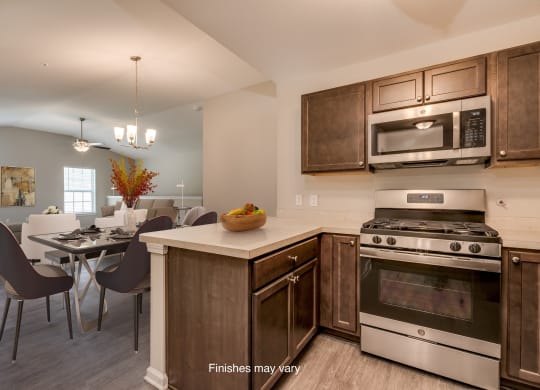 a kitchen and dining room with stainless steel appliances and wooden cabinets  at Killian Lakes Apartments and Townhomes, Columbia