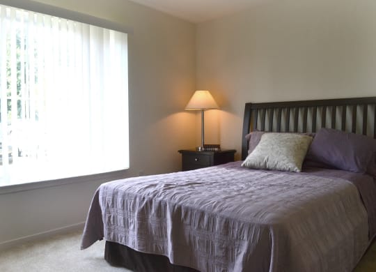 a bedroom with a bed and a window  at LakePointe Apartments, Batavia, OH, 45103