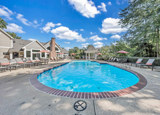 a resort style pool with chairs around it and houses in the background at Trophy Club at Bellgrade, Midlothian, VA, 23113