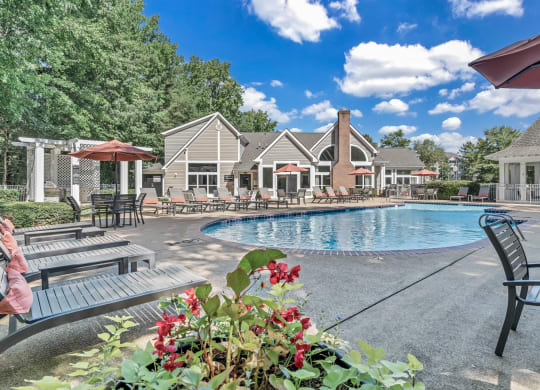 the resort style pool is surrounded by chairs and umbrellas at Trophy Club at Bellgrade, Midlothian, VA, 23113