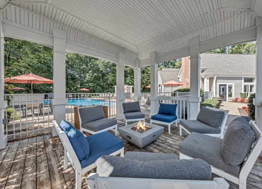 a covered porch with couches and chairs and a fire pit at Trophy Club at Bellgrade, Midlothian, VA, 23113