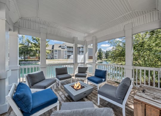a covered porch with couches and chairs and a fire pit at Trophy Club at Bellgrade, Midlothian, VA, 23113
