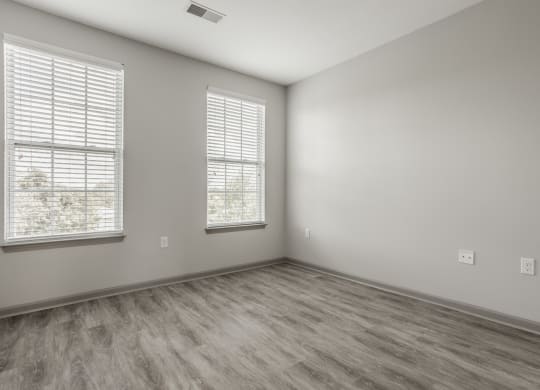 an empty room with wood flooring and two windows at The Avenue at Polaris Apartments, Columbus, OH