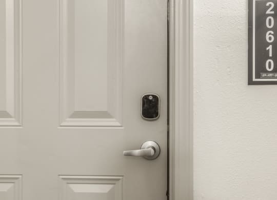 a white door with a black door handle and a white wall with a door number at The Avenue at Polaris Apartments, Columbus, OH