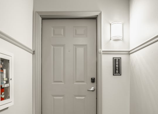 a white door in a hallway with a white wall and a door knob at The Avenue at Polaris Apartments, Columbus, OH