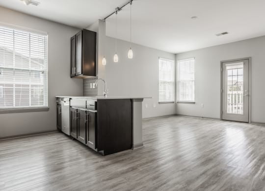 the living room and kitchen of an empty house with a large window at The Avenue at Polaris Apartments, Columbus, OH