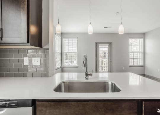 a kitchen with white counter tops and a sink at The Avenue at Polaris Apartments, Columbus, OH