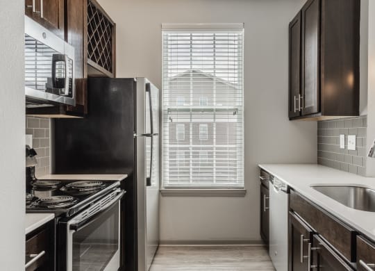 an empty kitchen with a window and a sink and refrigerator at The Avenue at Polaris Apartments, Columbus, OH