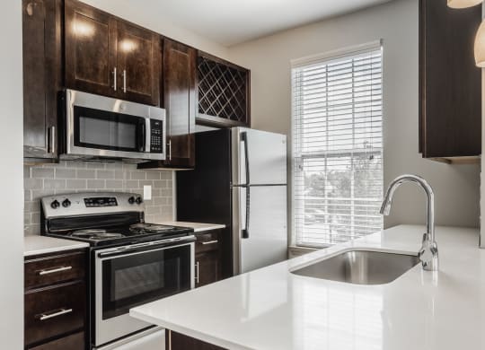an empty kitchen with a sink and a refrigerator at The Avenue at Polaris Apartments, Columbus, OH