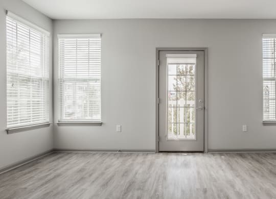 an empty room with a door and three windows at The Avenue at Polaris Apartments, Columbus, OH