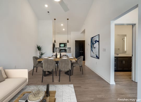 a dining area with a table and chairs and a kitchen in the background at Uptown Square Apartments, Michigan