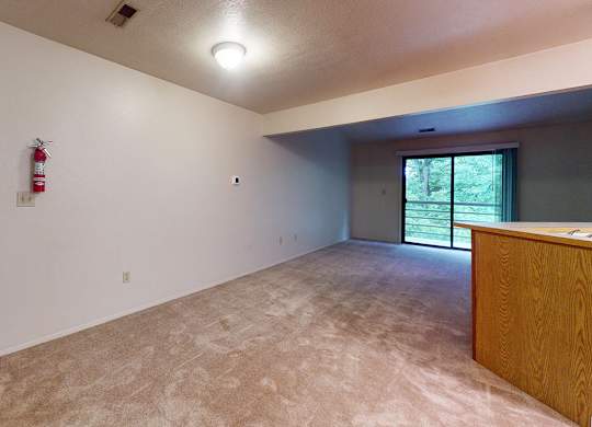 A dining and living room with a slider to a balcony at Emerald Park Apartments, Michigan