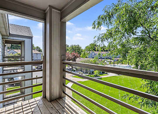 A balcony with a view of a green lawn at Emerald Park Apartments, Kalamazoo, Michigan