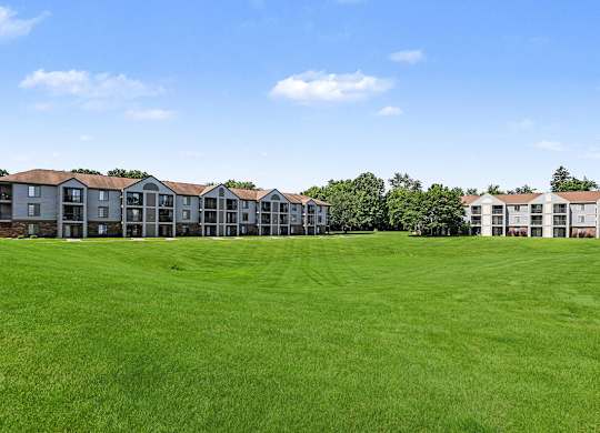 A row of apartment buildings with green lawns at Emerald Park Apartments in Kalamazoo, MI