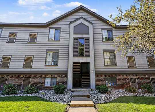 An apartment building with a sidewalk in front at Emerald Park Apartments in Kalamazoo, MI