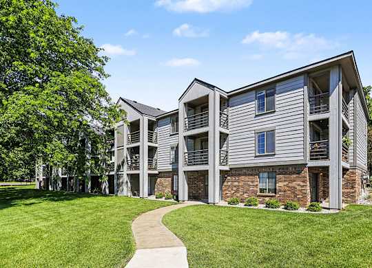 Apartment building with a walkway in front of it at Emerald Park Apartments in Kalamazoo, MI