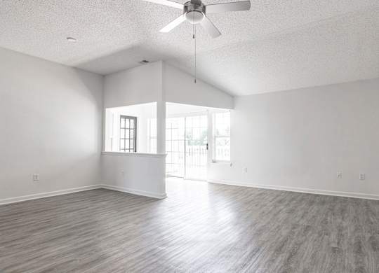 an empty living room with white walls and a ceiling fan at Latitudes Apartments, Indianapolis, IN, 46237