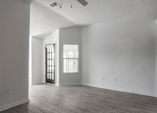 an empty living room with white walls and wood floors at Latitudes Apartments, Indianapolis, 46237
