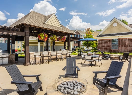 an outdoor patio with chairs and tables and a pavilion at The Avenue at Polaris Apartments, Columbus, OH