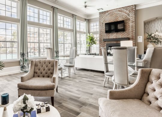 a living room with large windows and a table with chairs at The Avenue at Polaris Apartments, Columbus, OH