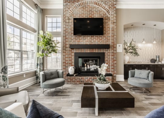 a living room with couches and a coffee table and a brick fireplace at The Avenue at Polaris Apartments, Columbus, OH
