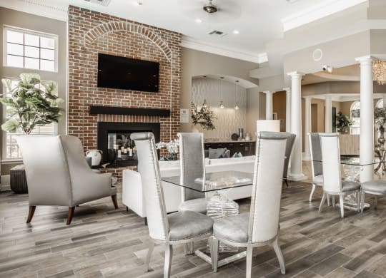 a dining room with a table and chairs and a brick fireplace at The Avenue at Polaris Apartments, Columbus, OH