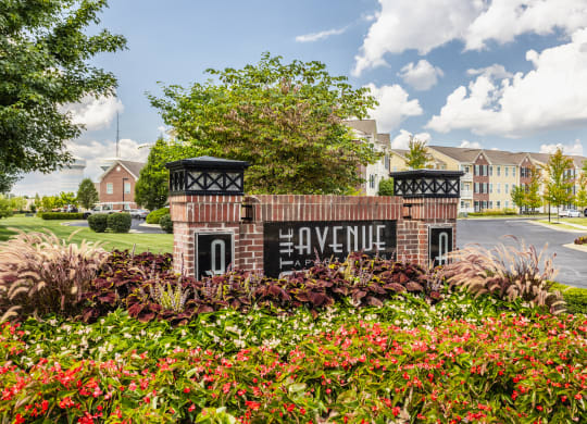 sign with flowers and buildings in the background at The Avenue at Polaris Apartments, Columbus, OH