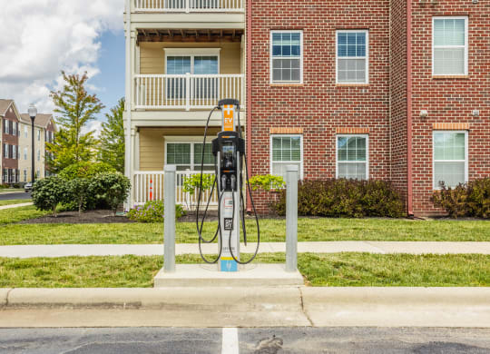 a gas pump sitting in front of a red brick building at The Avenue at Polaris Apartments, Columbus, OH
