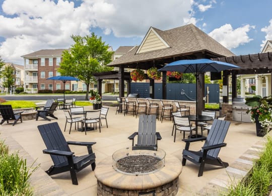 an outdoor patio with tables and chairs and a pavilion with umbrellas at The Avenue at Polaris Apartments, Columbus, OH