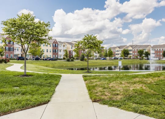 a park with a pond in front of an apartment building at The Avenue at Polaris Apartments, Columbus, OH