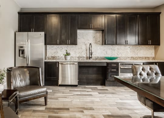a kitchen with dark wood cabinets and a stainless steel refrigerator at The Avenue at Polaris Apartments, Columbus, OH