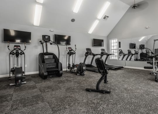 a gym with cardio machines and televisions in a building at The Avenue at Polaris Apartments, Columbus, OH