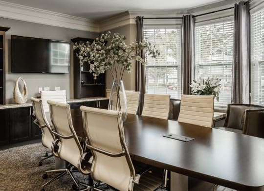 a dining room with a large table and chairs and a tv at The Avenue at Polaris Apartments, Columbus, OH