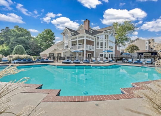 a large swimming pool with a house in the background at The Vinings Apartments in Richmond, VA