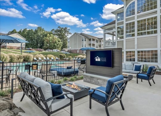a lounge area with chairs and a fireplace and a screened in porch with a pool at The Vinings Apartments in Richmond, VA