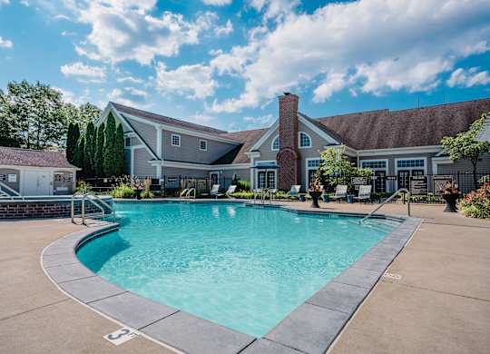 A large swimming pool in front of a house.