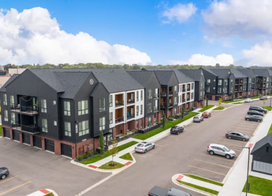an aerial view of a row of apartment buildings in a parking lot at Uptown Square Apartments, Michigan, 48083