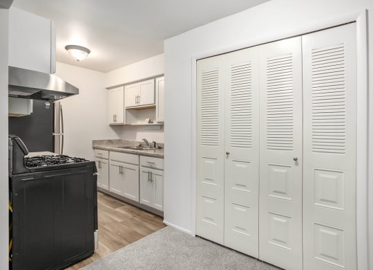 upgraded kitchen with white cabinets and a stove and a refrigerator at Fairlane Apartments in Springfield, MI