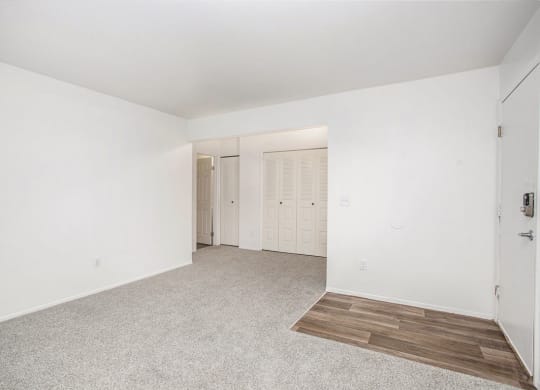 an empty living room with carpet and a closet at Fairlane Apartments in Springfield, MI