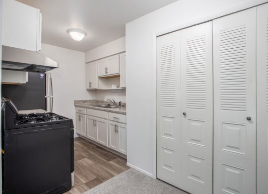 a kitchen with white cabinets and a large closet at Fairlane Apartments in Springfield, MI