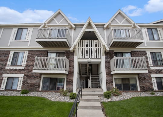Exterior brick apartment building with balconies and grass at Fairlane Apartments in Springfield, MI