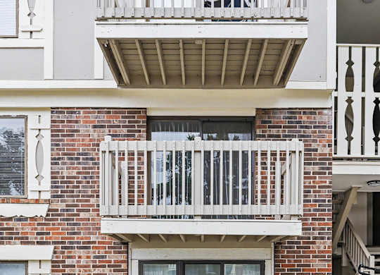 Apartment balconies with white railings and exposed beams at Fairlane Apartments, Springfield
