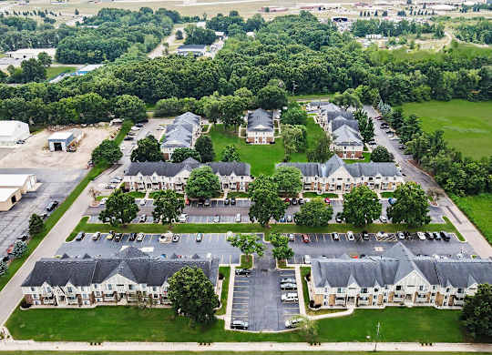 A bird's eye view of a residential area with apartment buildings and green grounds at Fairlane Apartments, Springfield, MI 49037