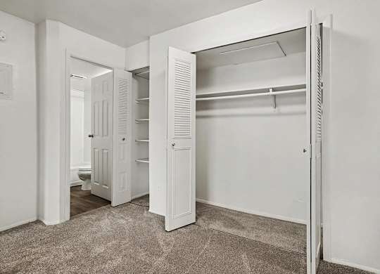Empty bedroom with open closet and shelving at Fairlane Apartments, Springfield, Michigan