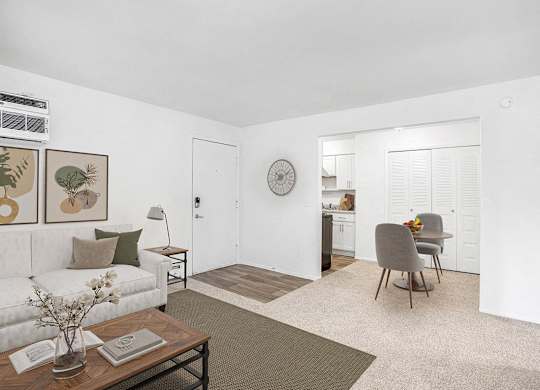 A living and dining room with plush carpeting at Fairlane Apartments, Springfield, Michigan