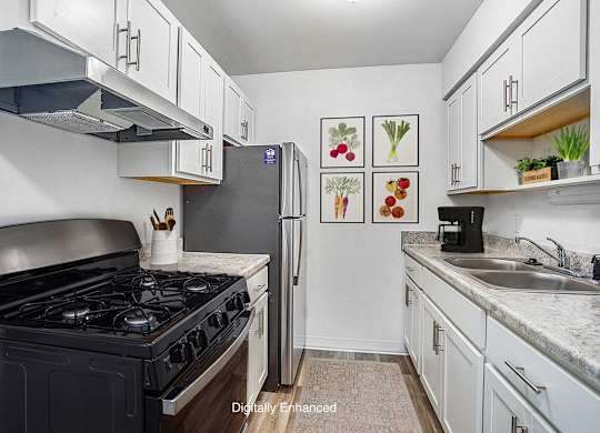An updated kitchen with a gas stove and white cabinets at Fairlane Apartments, Springfield, Michigan