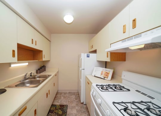 a gallery-style kitchen with a gas stove at Old Farm Apartments, Elkhart, Indiana