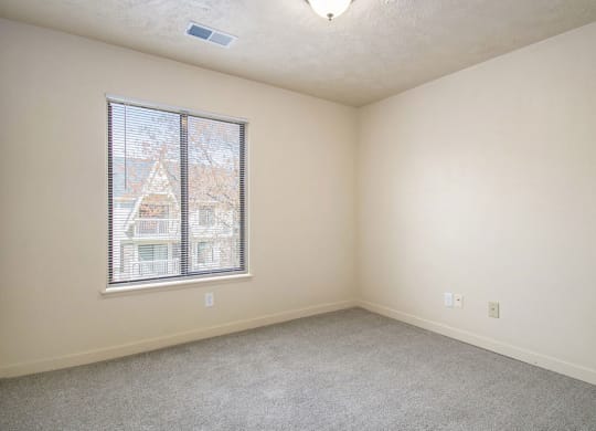 bedroom with a large window and carpeting at Old Farm Apartments, Elkhart, Indiana