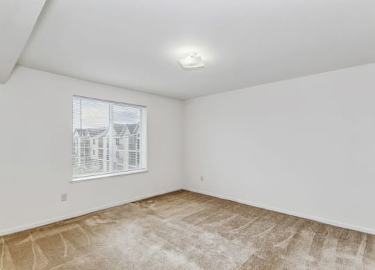 a bedroom with a window and plush carpeting at Fieldstream Apartment Homes, Ankeny, Iowa