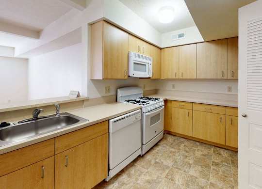 a kitchen with white appliances and a breakfast bar at Fieldstream Apartment Homes, Iowa